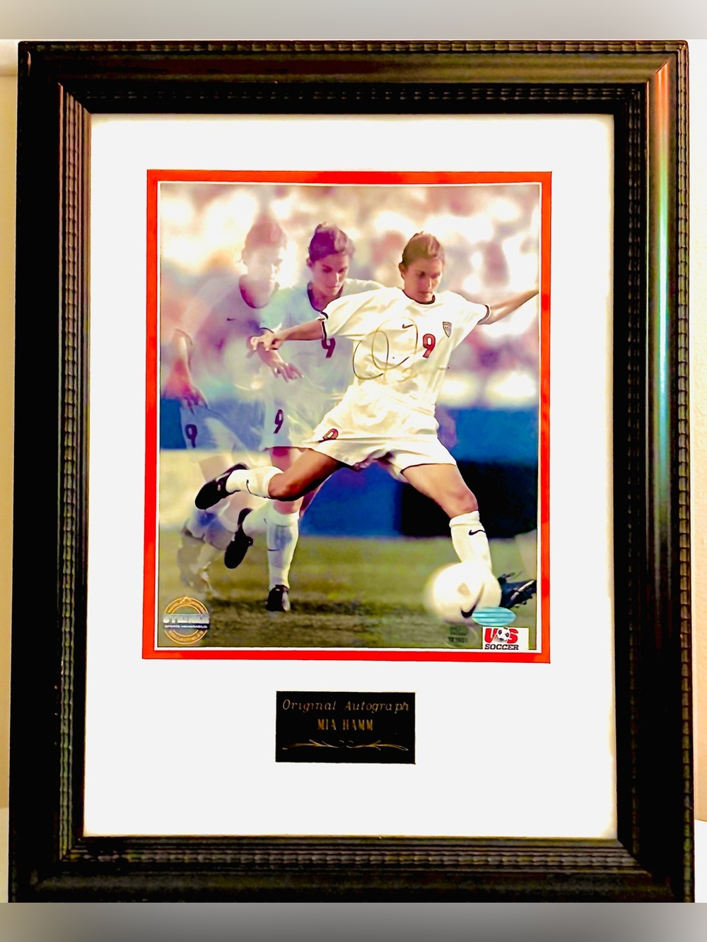 Framed signed photograph of former professional soccer player Mia Hamm.